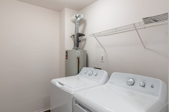 a white laundry room with a washer and a dryer