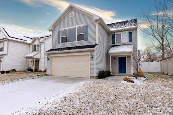 A house with a garage and a driveway covered in snow.