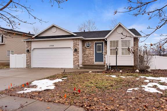 A house with a grey garage door and a black front door.