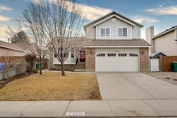 A house with a garage and a driveway in front of it.