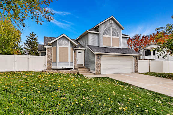 A house with a grey roof and a white garage door.