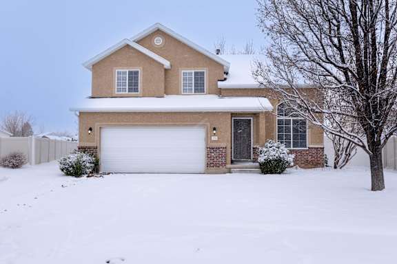 A house with a white garage door and a brown roof.