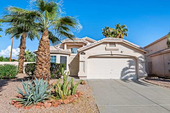 A house with a palm tree in front.