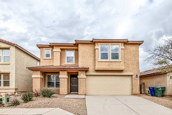 A two-story house with a garage and a driveway.