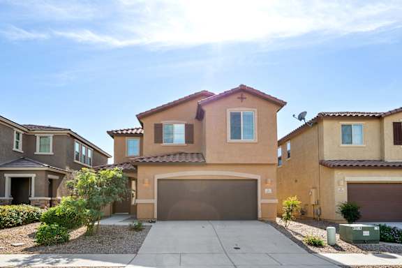 A house with a brown garage door in front of it.