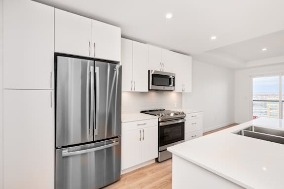 A modern kitchen with stainless steel appliances and white cabinets.
