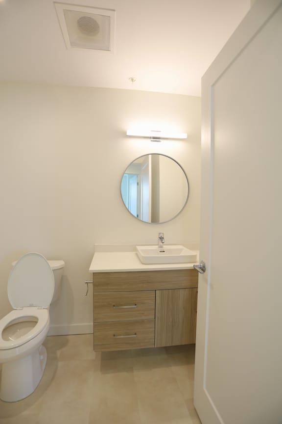 A white toilet sits next to a sink in a small bathroom.