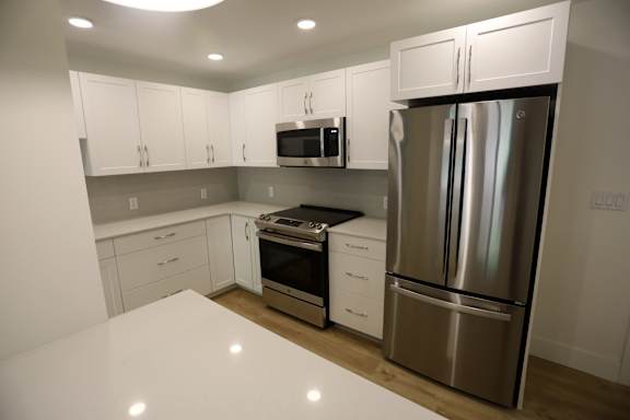 A kitchen with white cabinets and stainless steel appliances.