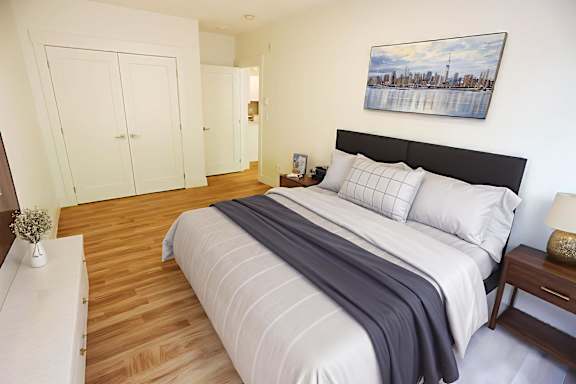 A bedroom with a large bed and a painting on the wall.