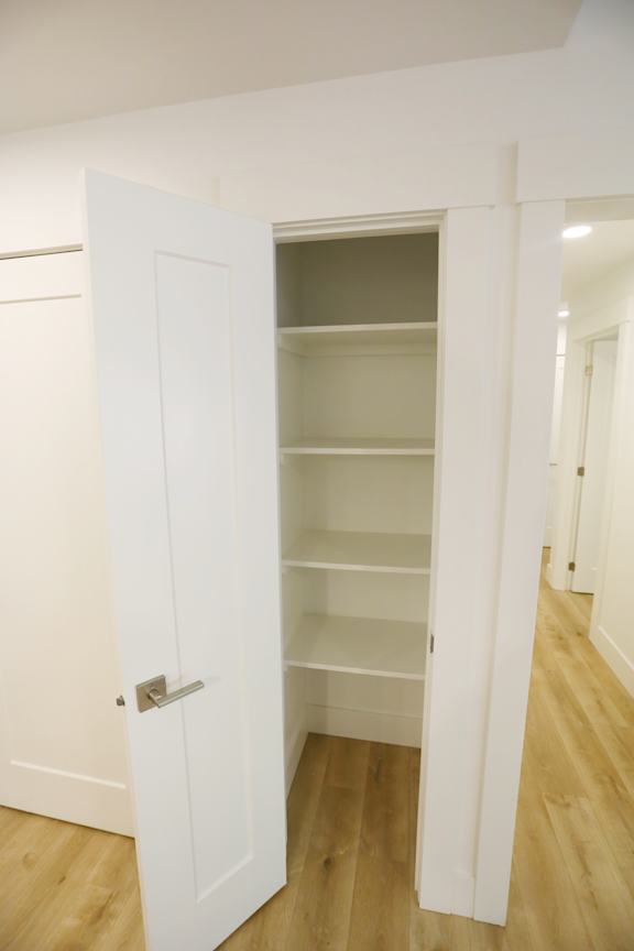 A white door is open to a room with shelves.