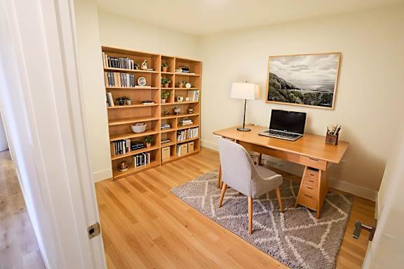 A room with a desk, chair, and bookshelf.