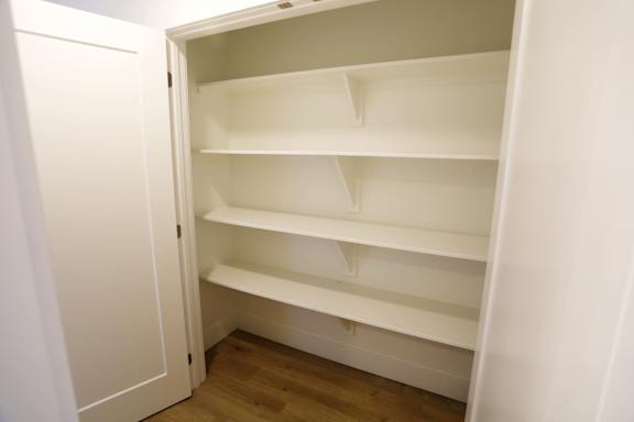 Empty white shelves in a white cabinet.