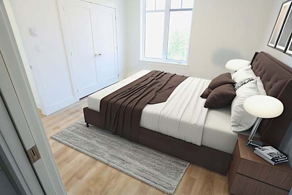 A bedroom with a brown headboard and a white bedspread.