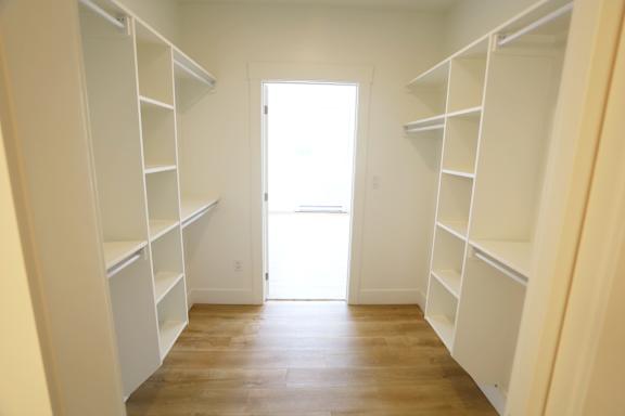 A room with white shelves and a door.