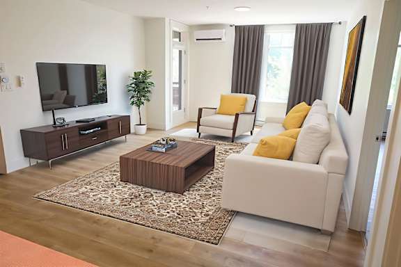 A living room with a white couch, a wooden coffee table, and a flat screen TV.