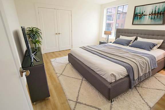 A bedroom with a large bed and a television on a cabinet.