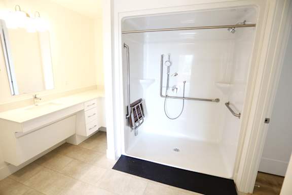 A white bathroom with a walk in shower.