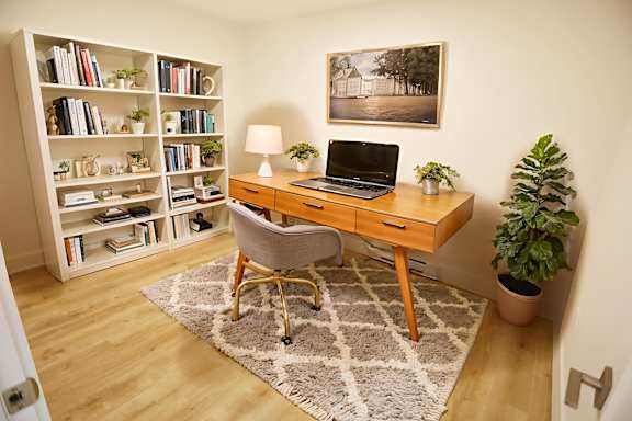 A room with a desk, chair, and bookshelf.