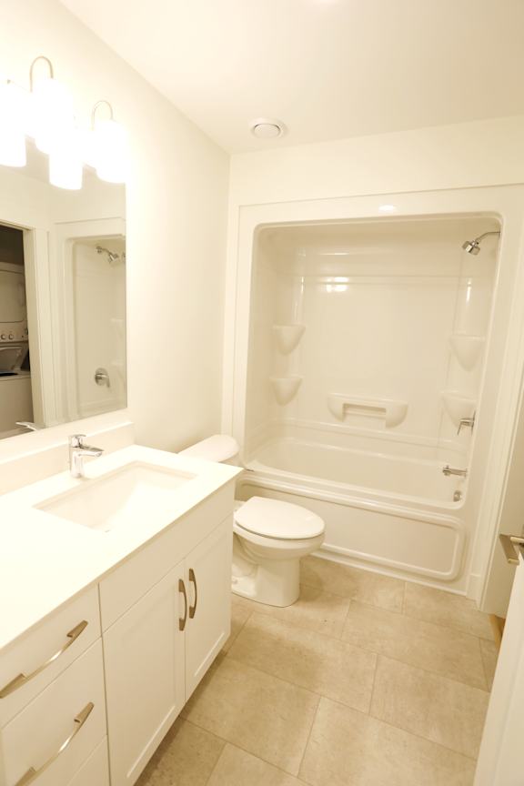A white bathroom with a toilet, sink, and bathtub.