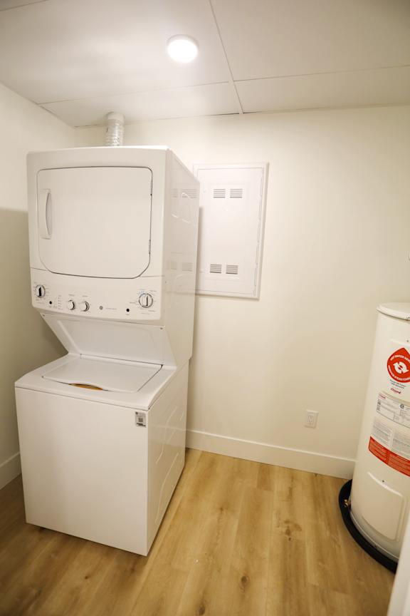 A white dryer and washing machine in a small room.