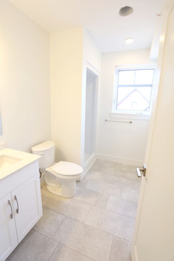 A white toilet sits in a bathroom next to a sink.