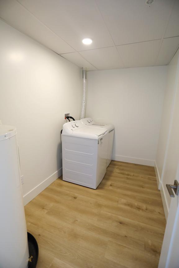 A white fridge and freezer in a room with wooden flooring.