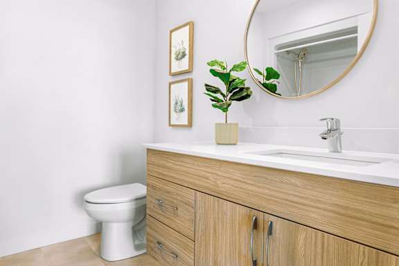 A bathroom with a toilet, sink, and a mirror.