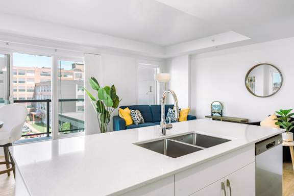 A modern kitchen with a large island and a view of the city.