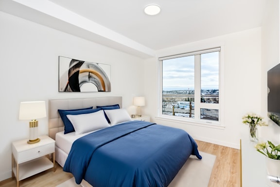 A bedroom with a large bed and a view of the city.