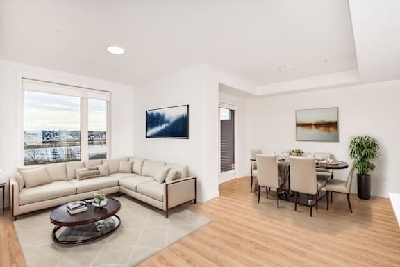 A living room with a couch, coffee table, and dining table.