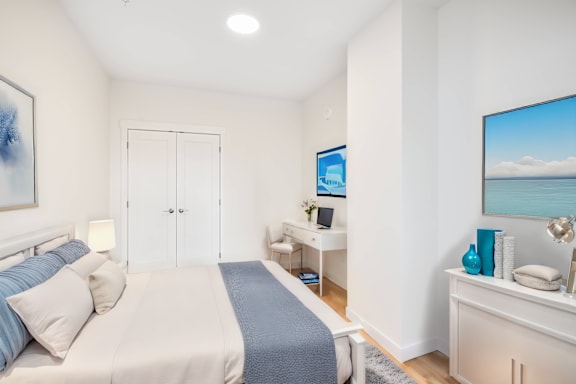 A bedroom with a bed, desk, and chair.