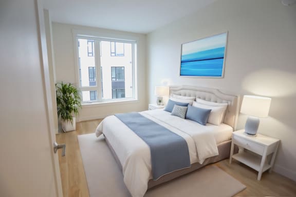 A bedroom with a large bed and a painting on the wall.