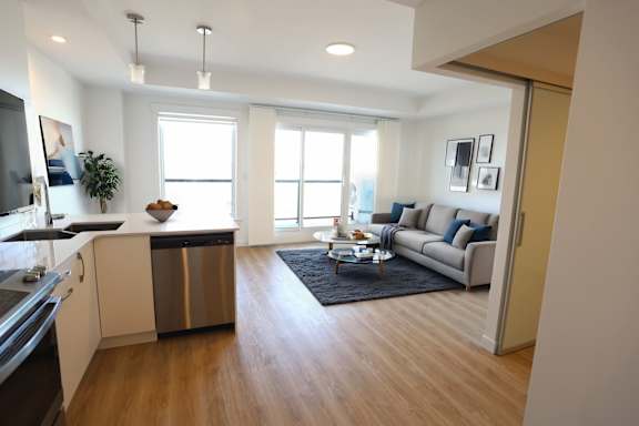 A modern kitchen with a large window and a wooden floor.