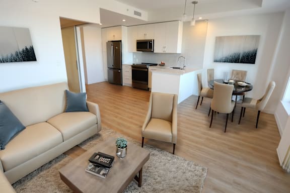 A living room with a couch, chairs, and a coffee table.