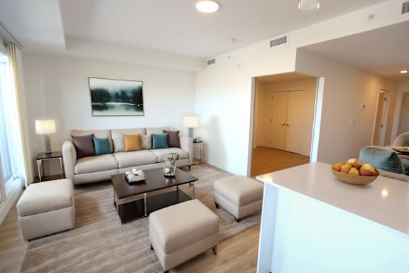 A modern living room with a grey carpet and a white sofa.