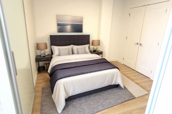 A bedroom with a large bed and a painting above it.
