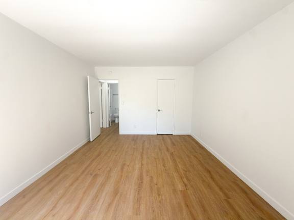 A long hallway with a white door at the end.