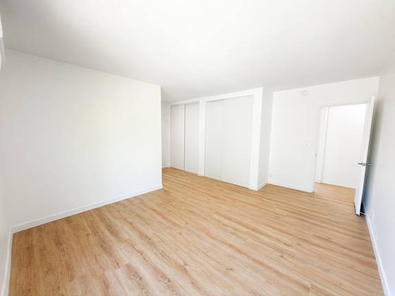 A room with wooden flooring and white walls.