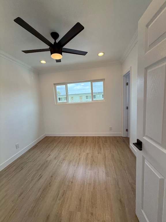 A room with a ceiling fan and wooden flooring.