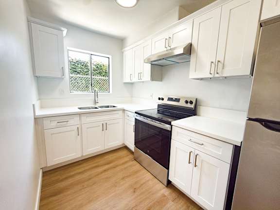 A kitchen with white cabinets and a black stove top oven.