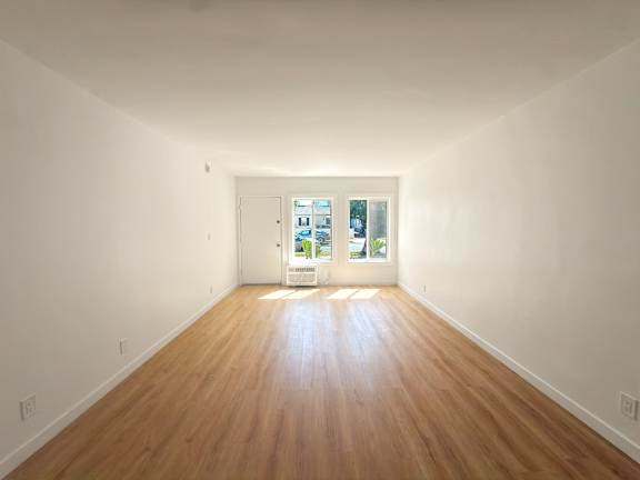 A room with wooden floors and a white door.