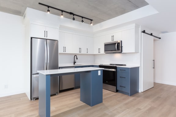 a kitchen with white cabinets and stainless steel appliances and a blue counter top