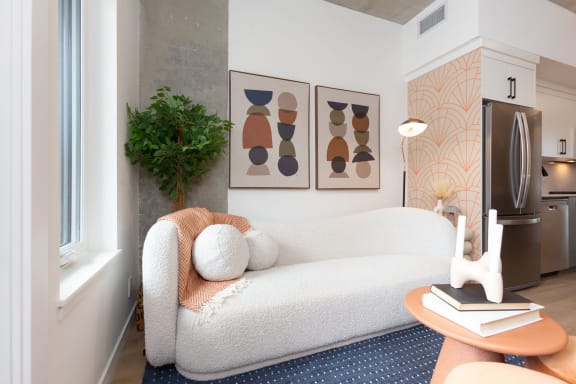 a living room with a couch and two paintings on the wall