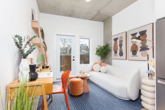 a living room with a couch and a desk and a door