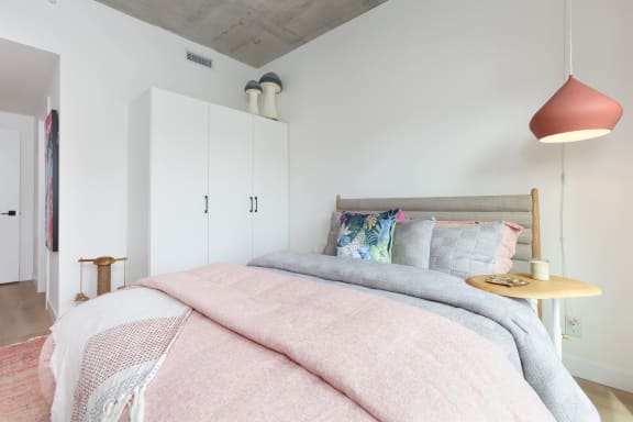 a bedroom with a bed and a peach lamp