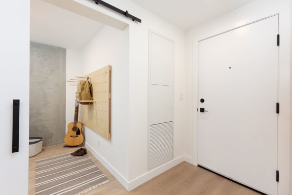 a room with white walls and a closet and a guitar