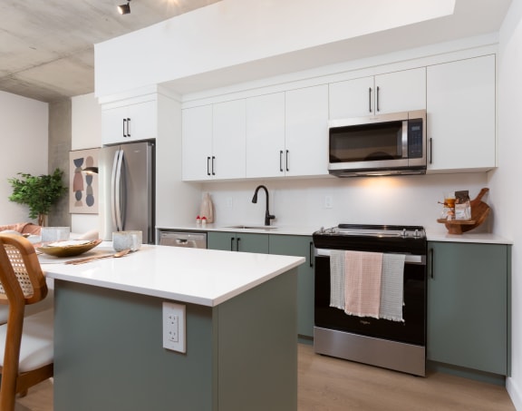 a kitchen with white cabinets and a white counter top and a stainless steel refrigerator