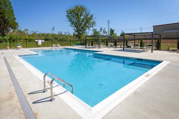 A large outdoor swimming pool with a metal railing.