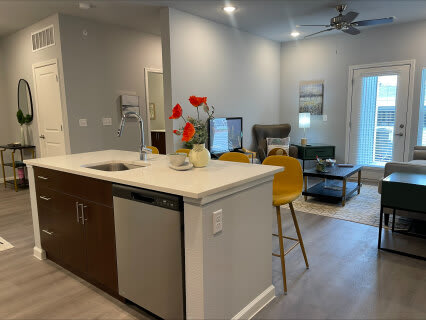 a kitchen with an island in the middle of a living room