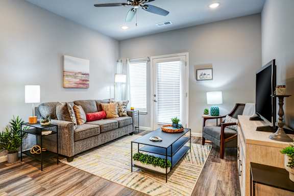 A living room with a couch, a coffee table, and a television.